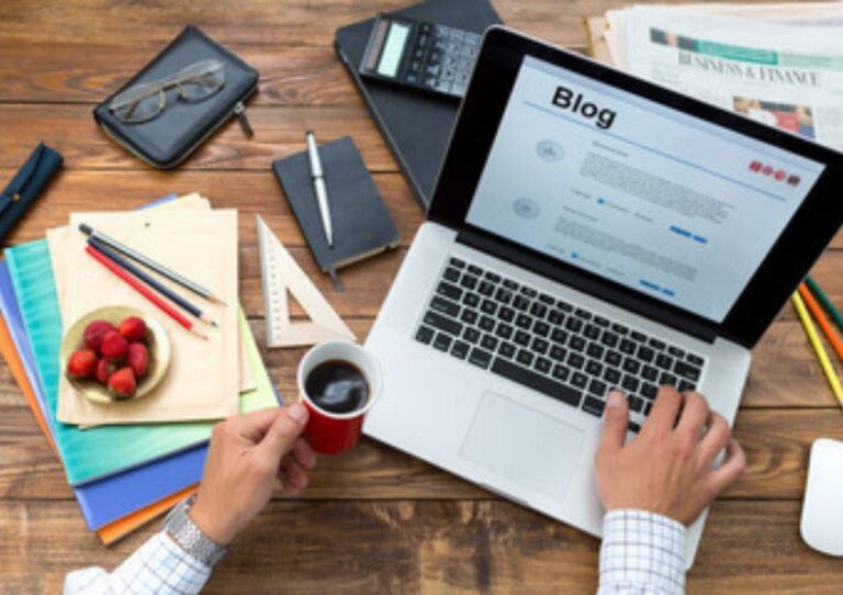 Imagem mostra mãos de um homem segurando uma xícara de café, sobre a mesa com um notebook escrevendo em um blog utilizando 5 Estratégias Essenciais de SEO Para Sua Empresa Conquistar Mais Clientes na Internet Conteúdo de Qualidade